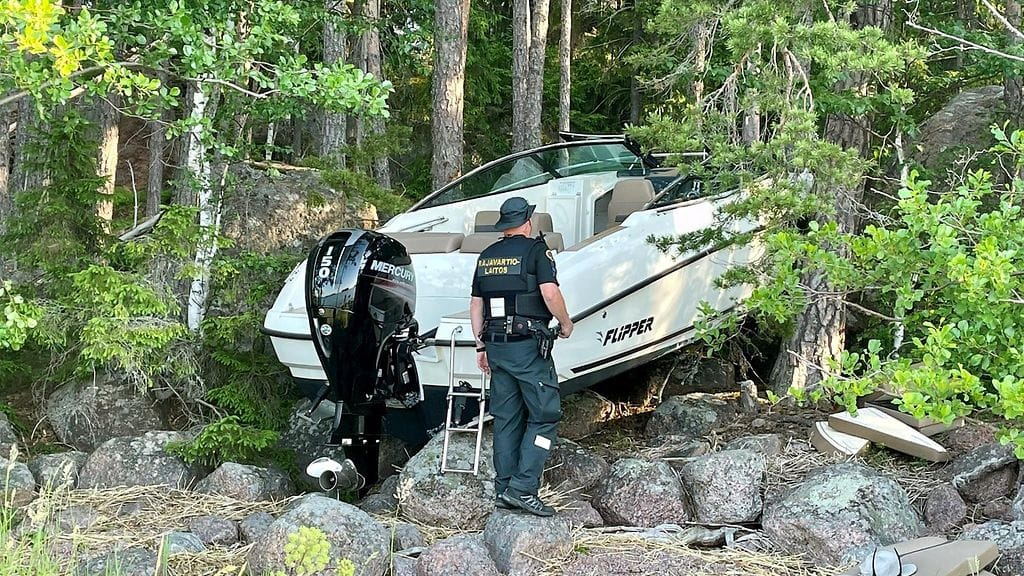 Kuva rantaan ajautuneesta moottoriveneestä.