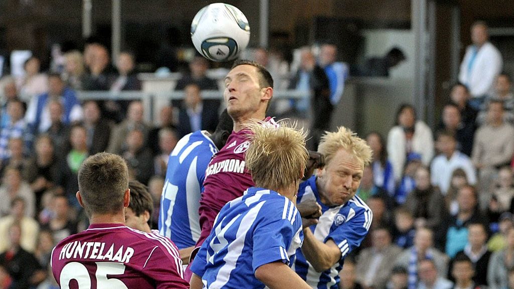 Schalken Benedikt Höwedes HJK-pelaajien puristuksessa.
