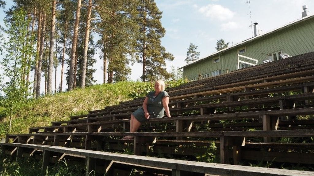 Anne Repo istuu jokiareenan katsomossa ja ihailee jokea.