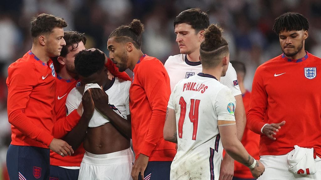 Joukkuetoverit lohduttivat rangaistuspotkussa epäonnistunutta Englannin Bukayo Sakaa.