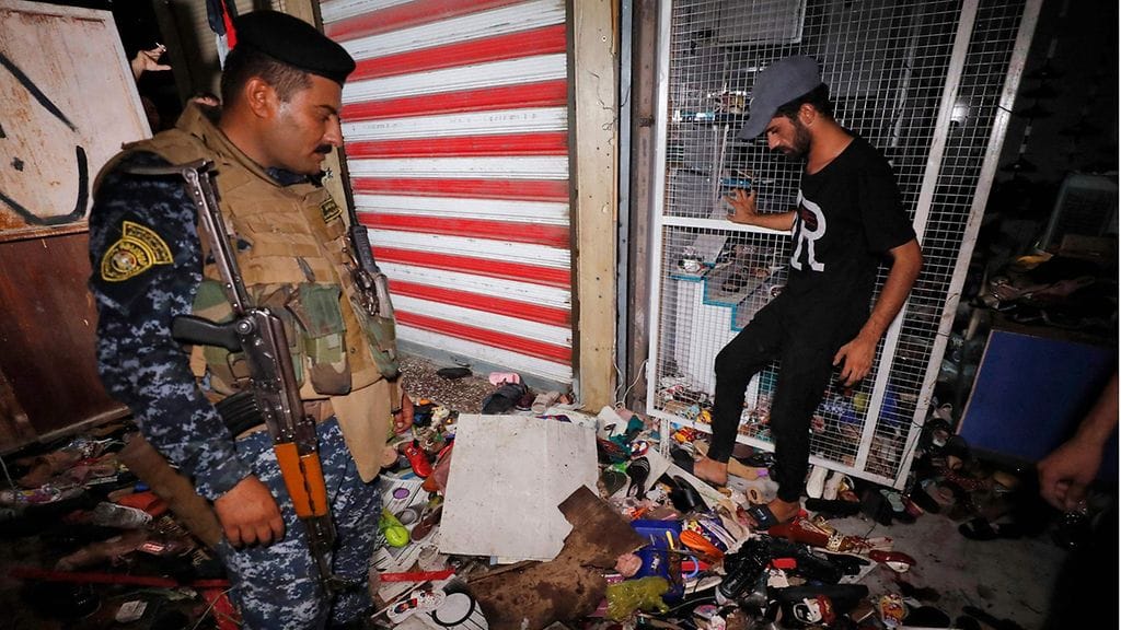 Irakilaiset tutkivat pommi-iskun jälkiä.