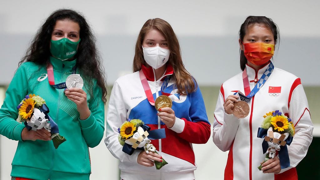 Venäjän Vitalina Batsarashkina (keskellä), Bulgarian Antoaneta Kostadinova (vas.) ja Kiinan Ranxin Jiang poseerasivat Tokion olympialaisten palkintokorokkeella naisten 10 metrin ilmapistooliammunnan jälkeen.