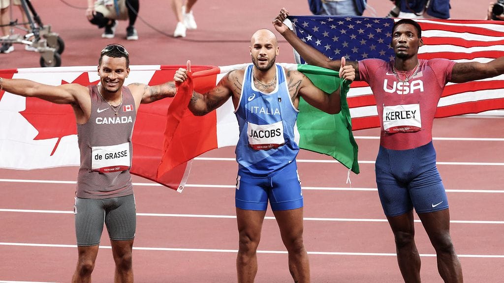 Italian Lamont Marcell Jacobs (kesk), Yhdysvaltojen Fred Kerley ja Kanadan Andre De Grasse juhlivat mitaleita satasen olympiafinaalissa.