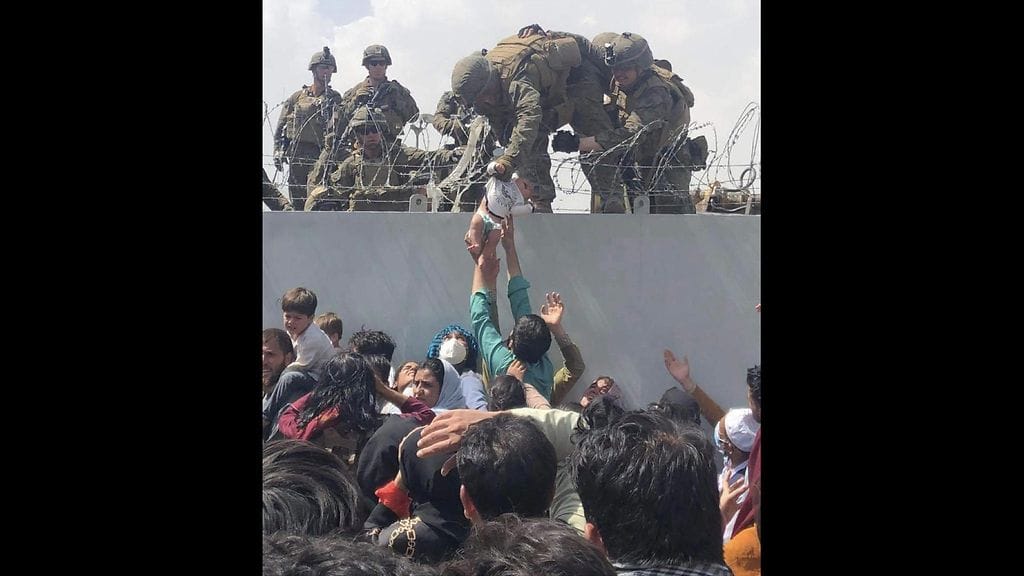 Sotilaat ottivat vastaan vauvan, joka nostettiin Kabulin lentokentän muurin yli.