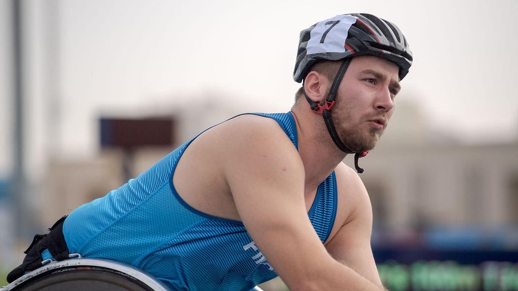 Henry Manni kantaa Suomen lippua Tokion paralympialaisten avajaisissa.