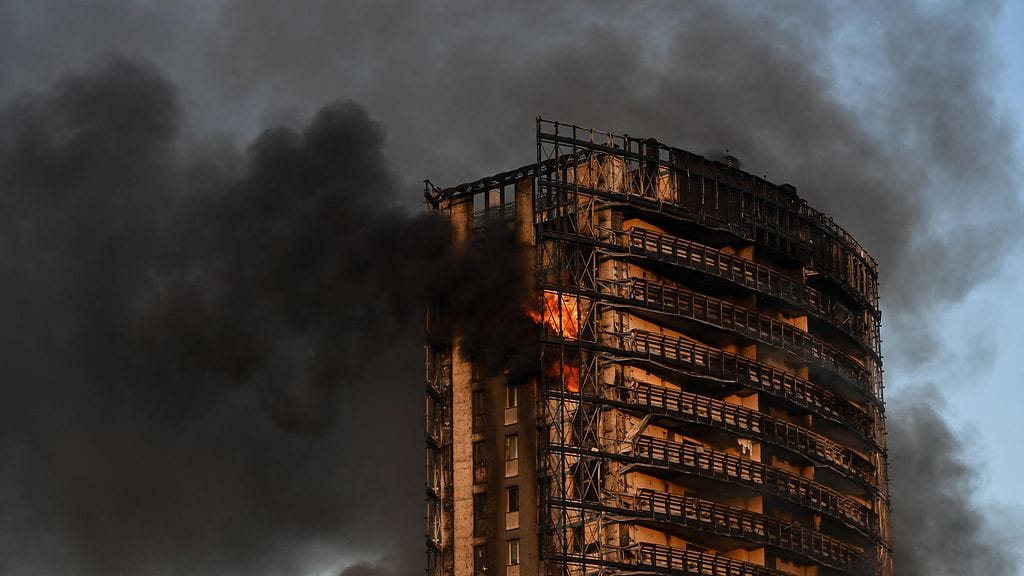 Kerrostalon kyljestä puskee lieskoja ja musta savu täyttää taivaa.