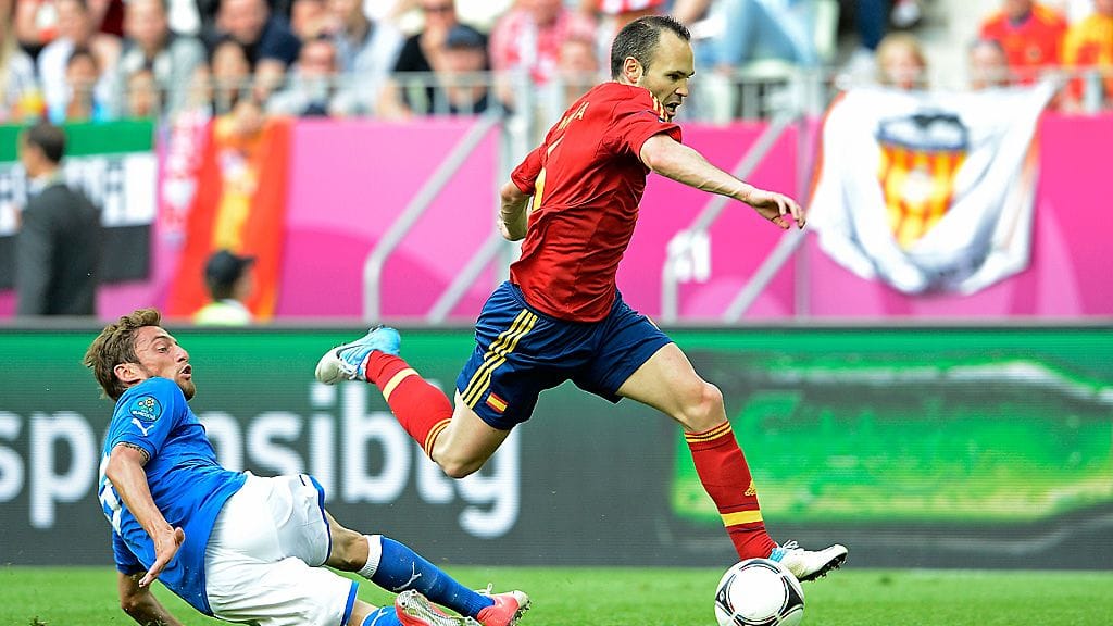 Espanjan Andres Iniesta karkaa Italian Claudio Marchisiolta lohkovaiheen pelissä.