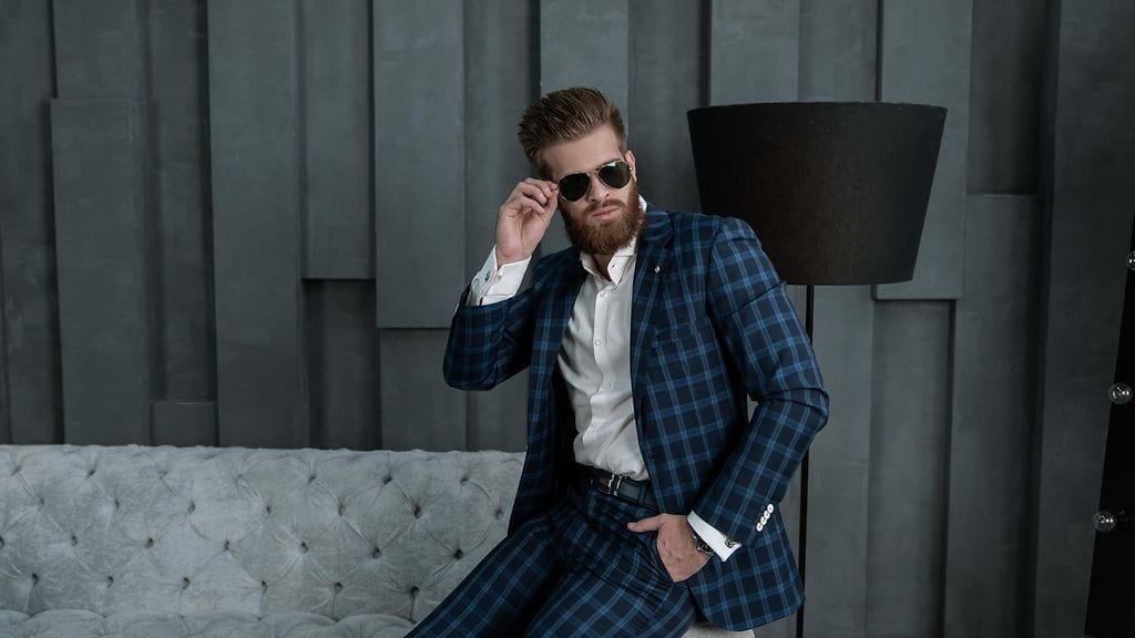 mies poseeraa aurinkolasit päässä