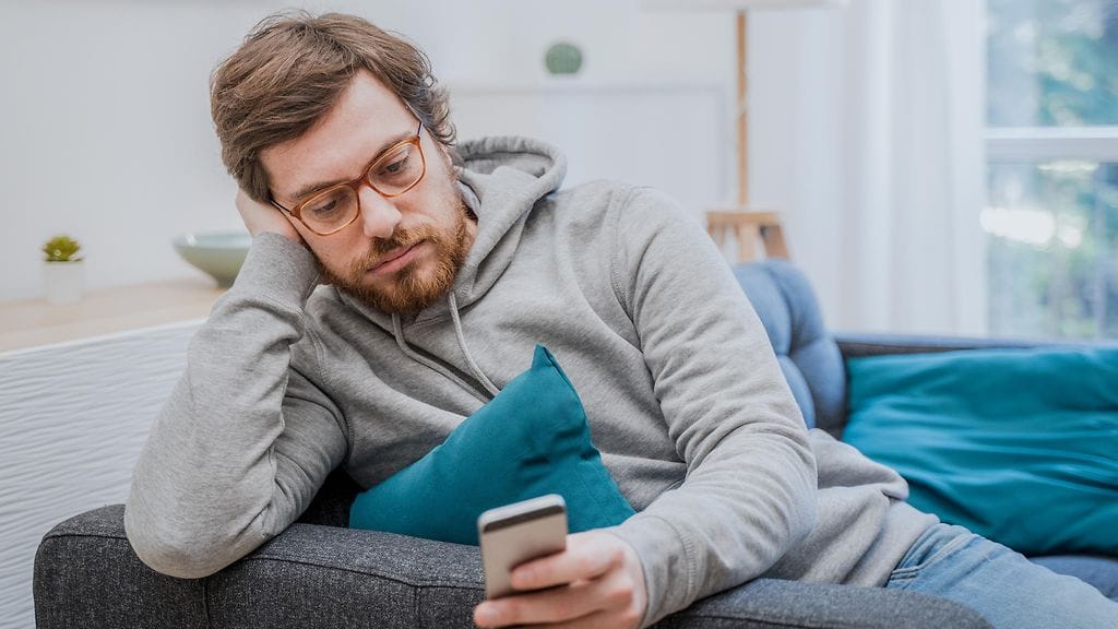 mies odottamassa puhelinsoittoa