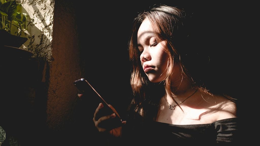 nainen selaamassa puhelintaan