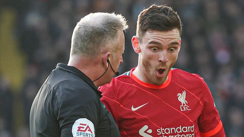 Liverpoolin Andrew Robertsonin kasvoilla kävi hämmästynyt ilme, kun hän kävi keskustelua erotuomari Jonathan Mossin kanssa.