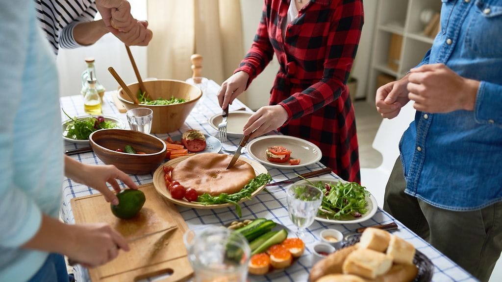 ystävät laittavat ruokaa kotona