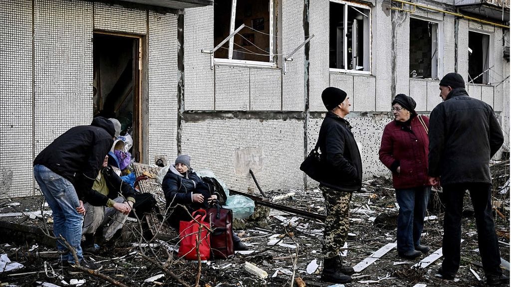 Ihmisiä pommituksessa tuhoutuneen rakennuksen ulkopuolella Tšuhujivissa, Harkovan alueella Itä-Ukrainassa 24. helmikuuta.