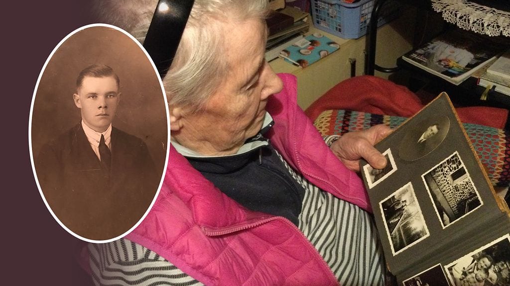 Helga Aaltonen katselee isänsä Ilmari Koskisen valokuvaa.