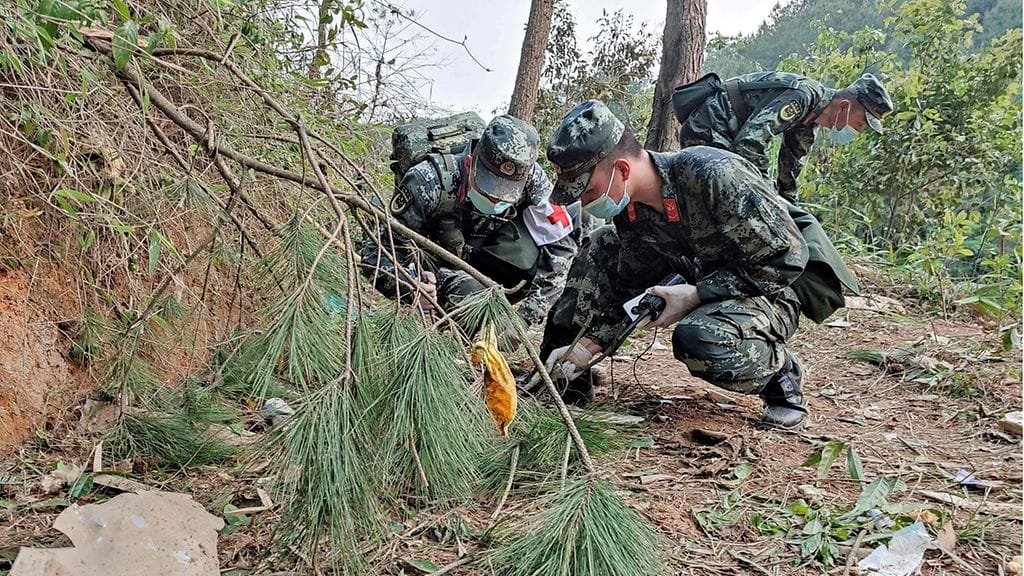 Maanantaina 21. maaliskuuta otetussa kuvassa puolisotilaalliset poliisit suorittavat etsintöjä China Eastern Airlinesin lento-onnettomuuspaikalla Wuzhoun kaupungissa Kiinan eteläisellä Guangxin alueella.