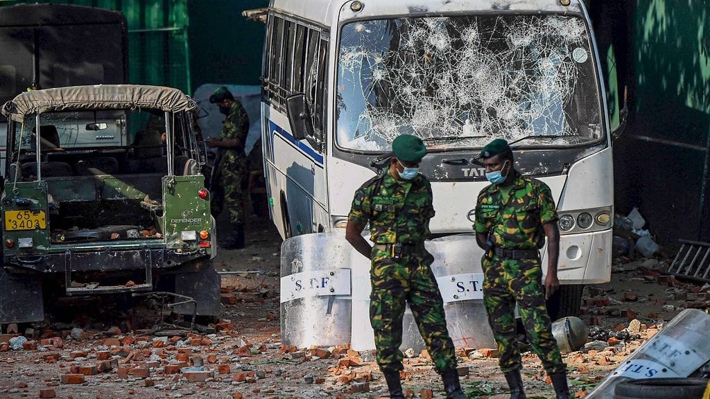 Sotilaat seisoivat vahingoitetun ajoneuvon edessä lähellä presidentti Rajapaksan kotia Sri Lankassa.