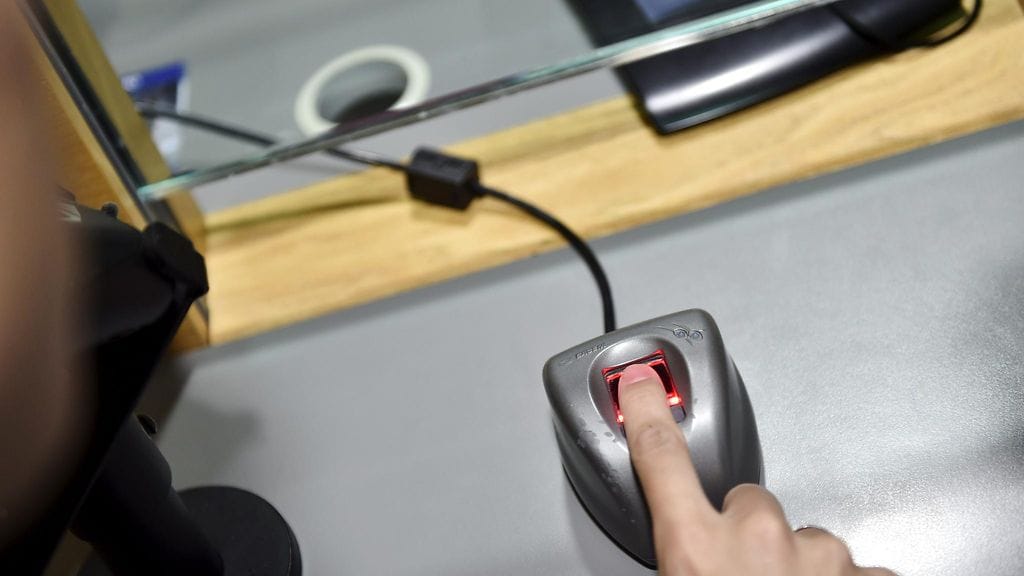 Sormenjälkien skannaus passihakemusta varten poliisiasemalla Helsingissä heinäkuussa 2018. Tilanne on lavastettu.