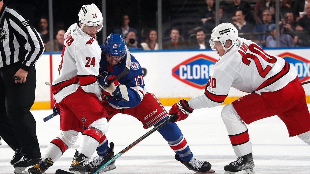 Sebastian Aho ja Seth Jarvis taistelivat kiekosta Rangersin Kevin Rooneyn kanssa.