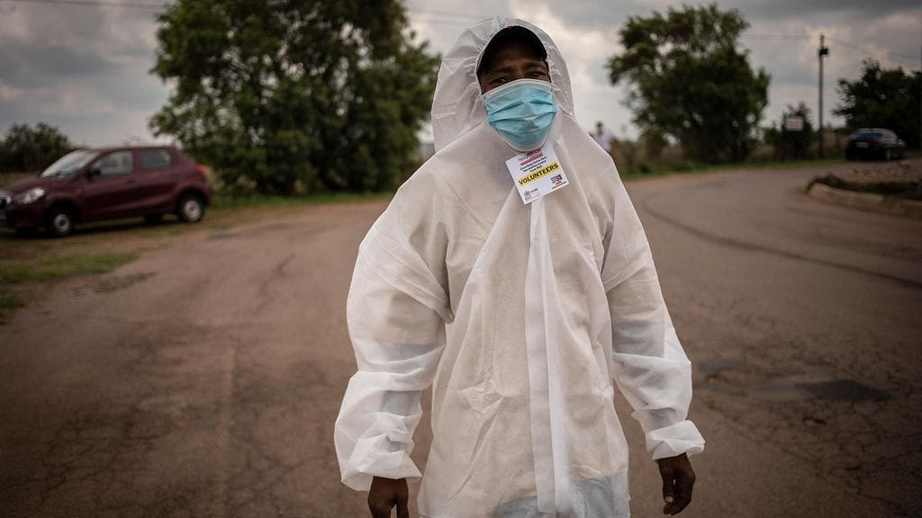Suojapukuinen vapaaehtoinen antoi koronarokotuksia Pretoriassa Etelä-Afrikassa.