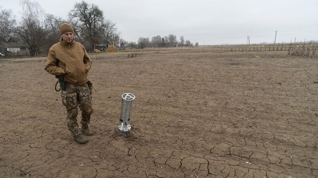Ukrainan armeijan sotilas venäläisjoukkojen ampuman rypälepommin jäänteiden äärellä maaliskuussa.