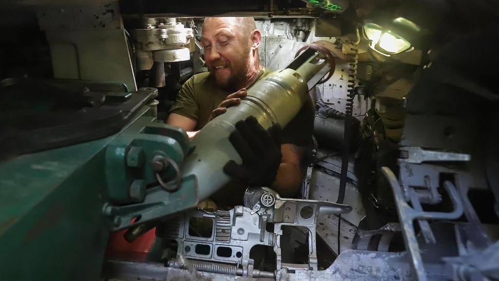 Ukrainalainen sotilas kantamassa ammuksia panssarivaunuun Itä-Ukrainassa.