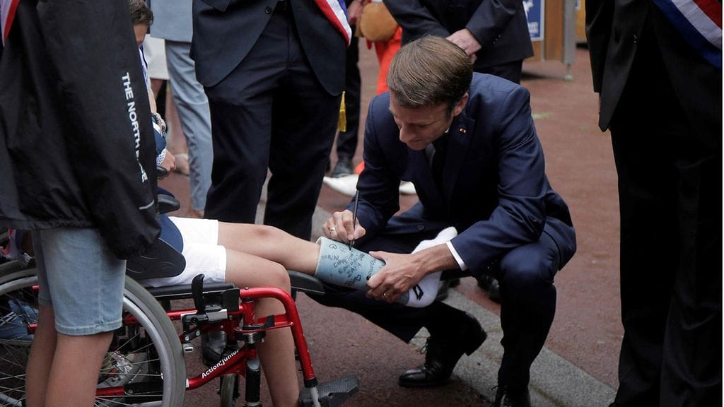 LK 19.6.2022 Ranskan presidentti Emmanuel Macron kirjoitti nimikirjoituksensa pojan jalassa olevaan kipsiin saapuessaan äänestyspaikalle Pohjois-Ranskassa Le Touquet’ssa tänään 19.6.2022.