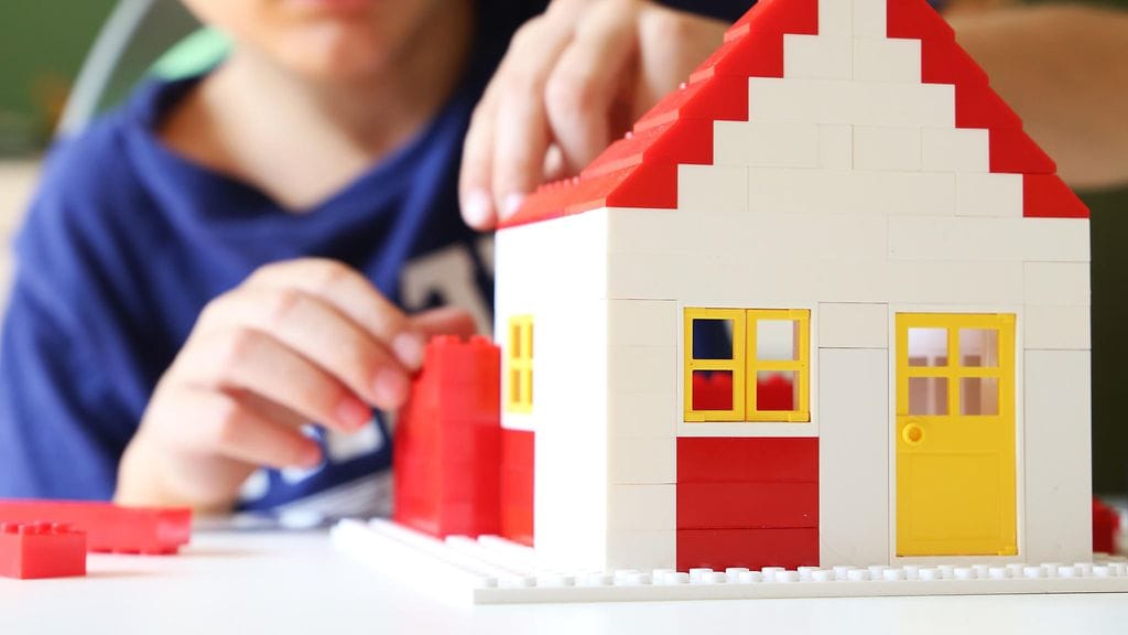 lapsi rakentaa leikkitaloa