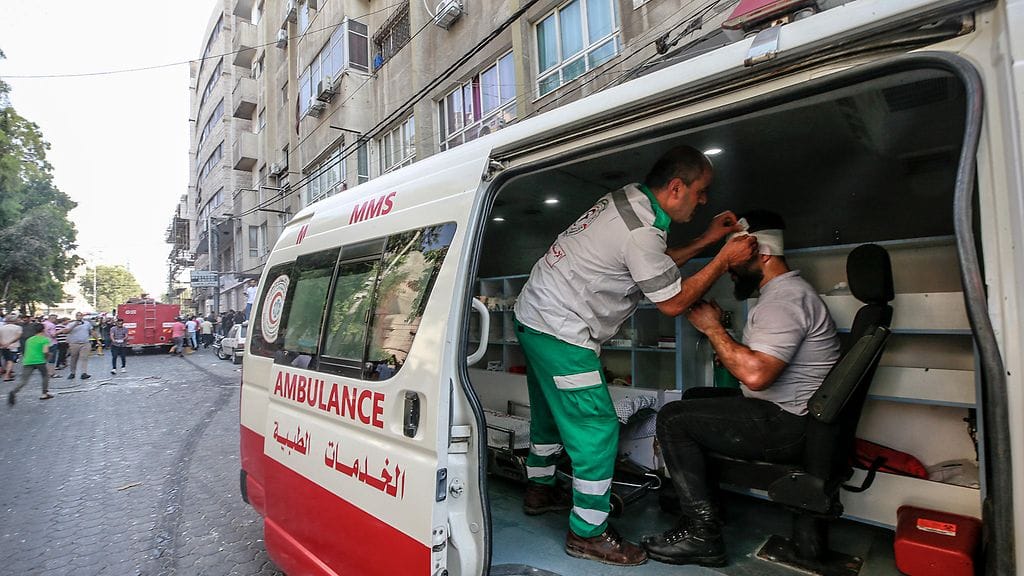 Palestiinalaismies saa ensiapua Israelin armeijan tekemän iskun jälkeen.