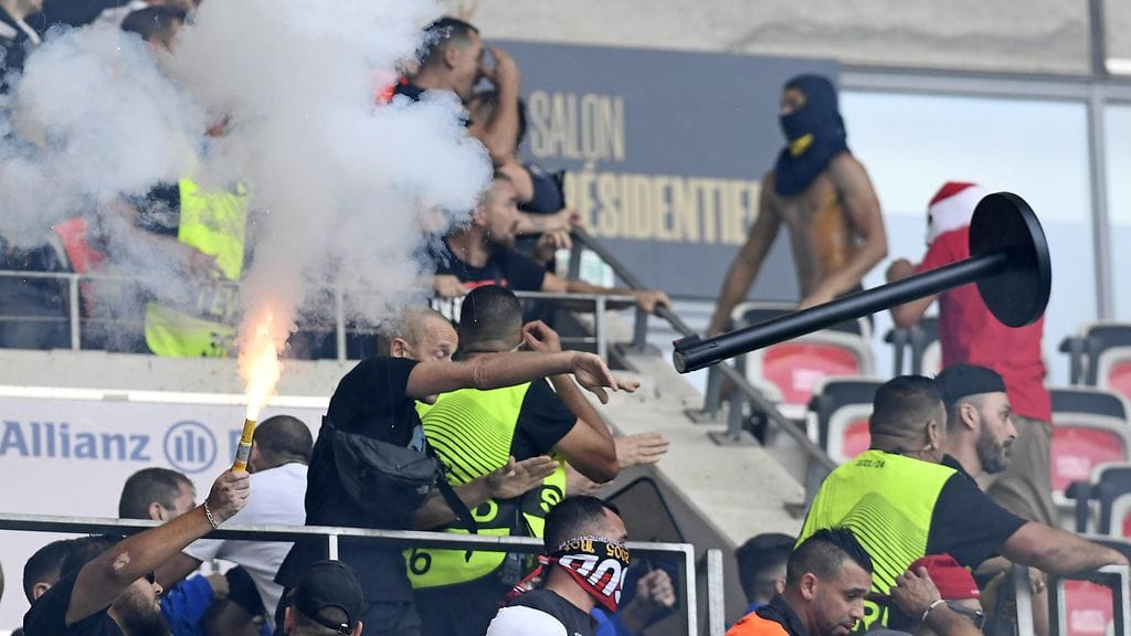 Joukkueiden kannattajat viskoivat irtotavaraa ja soihtuja toistensa suuntaan.