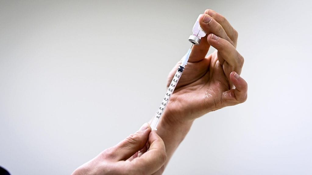 Koronarokotteiden uudet tehostusannostukset tarjotaan perusterveille aikuisille todennäköisesti työterveydessä ja yksityisessä terveydenhuollossa. Kuvituskuvassa hoitaja valmistaa Pfizer-BioNTech COVID-19 rokotetta Lintuvaaran rokotuspisteessä Espoossa 23. huhtikuuta 2021.