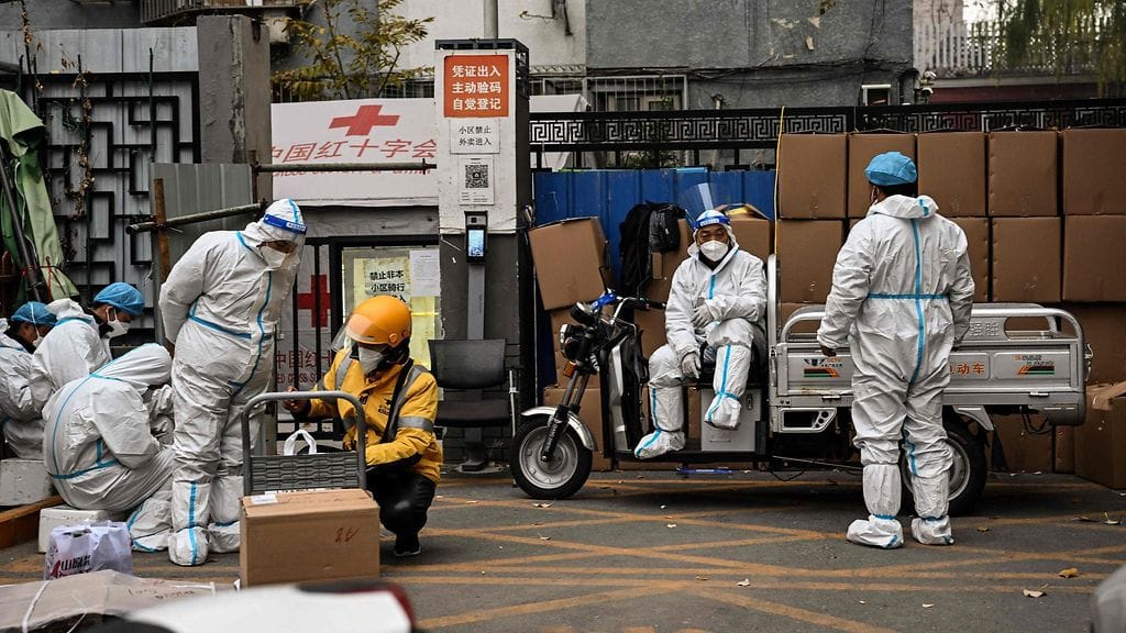 Terveydenhuollon työntekijät vartioivat asuinalueen sisäänkäyntiä koronasulun aikana Pekingissä Kiinassa tänään torstaina.