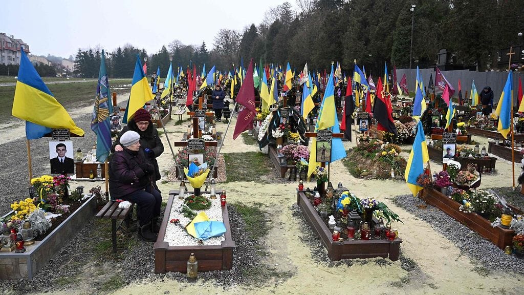 LK 6.12.2022 Iäkäs nainen suri ukrainalaissotilaan haudalla Lytšakivin hautausmaalla Ukrainassa Lvivin kaupungissa 6.12.2022.