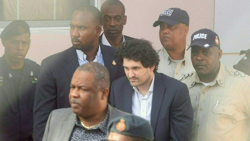 LK 26.12.2022 Sam Bankman-Fried (C) is led away handcuffed by officers of the Royal Bahamas Police Force at the Nassau, Bahamas, courthouse on December 19, 2022.