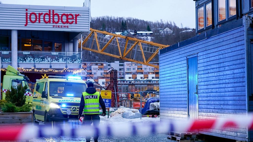 Nostokurki kaatuneena ostoskeskuksen päälle. Etualalla poliisinauha.