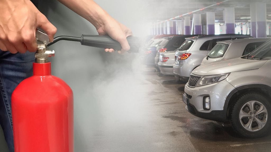 Kuvituskuva. Kuvan henkilö, sammutin, pysäköintihalli ja autot eivät liity tapaukseen.