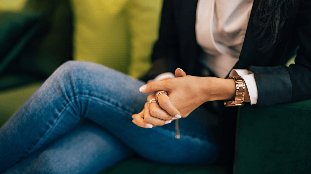 nainen istuu jalat ristissä