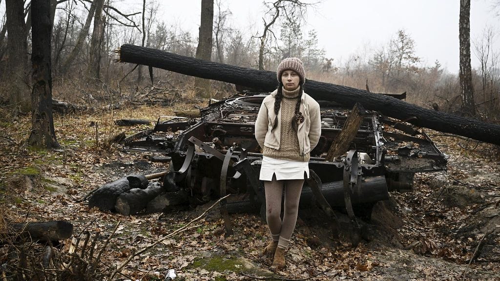 Kateryna Papina ja tuhottu venäläispanssari miinoitetulla alueella Mylan kylän lähistöllä Ukrainassa 11. maaliskuuta 2023.,