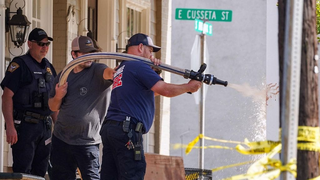 Palomiehet pesevät veristä kädenjälkeä ampumapaikalla Dadevillessa.