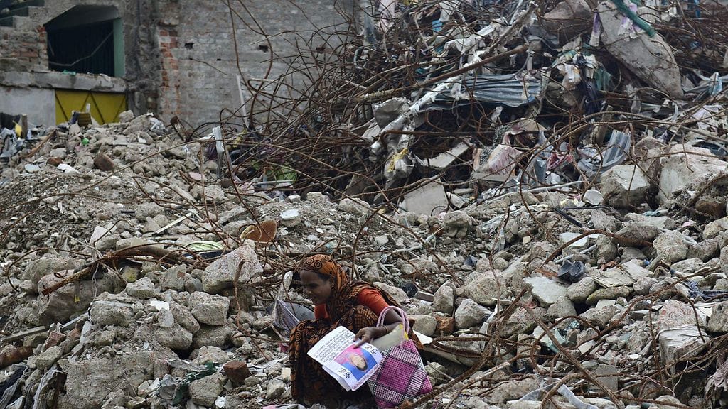 Vaatetehtaan ulkopuolella nähtiin surijoita tragedian jälkeen. Kuva on otettu 2. elokuuta 2013, kun romahduksesta oli kulunut 100 päivää.