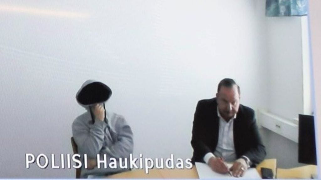 Nuori mies piiloutui huppariinsa vangitsemisistunnon alussa. Oikealla nuorukaisen avustaja, asianajaja Kari Eriksson.