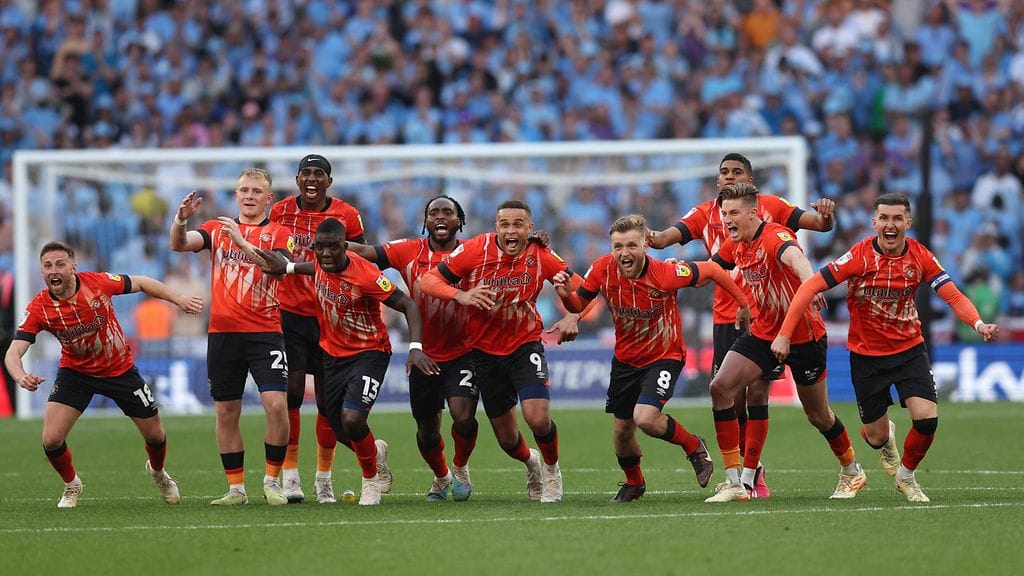 Lutonin pelaajat tuulettavat valioliiganousua Coventryn Fankaty Dabon epäonnistuttua rangaistuspotkukilpailun kuudennella kierroksella.