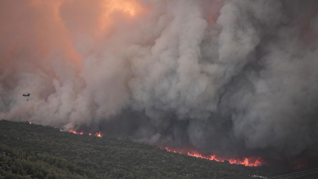 Metsäpalot ovat kurittaneet Kreikkaa pitkin kesää. Kuvassa Chinook-helikopteri lentää maastopalon yllä lähellä Pournarin kylää Dervenochoriassa, Attikan alueen luoteisosassa Kreikassa 18. heinäkuuta 2023.