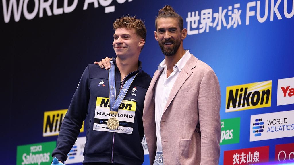 Tuore maailmanennätysmies Leon Marchand (vasen) sai onnittelut päihittämältään Michael Phelpsiltä.