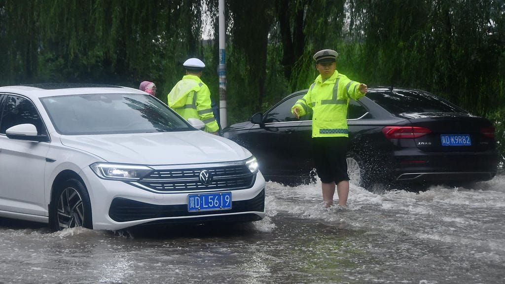 Liikennepoliisi ohjasi liikennettä rankkasateessa Handanissa 31. heinäkuuta.