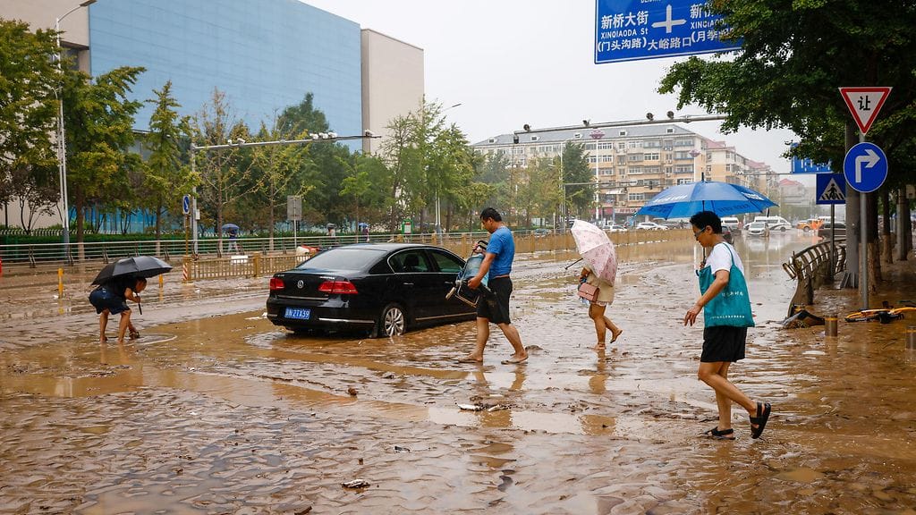 Ihmisiä rankkasateiden runtelemassa Mentougoussa läntisessä Pekingissä 1. elokuuta 2023.