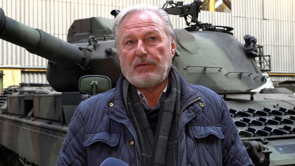 Freddy puhuu haastattelussa, taustalla Leopard-tankki.