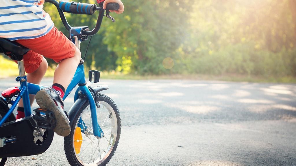 Lapsi opettelee ajamaan pyörällä
