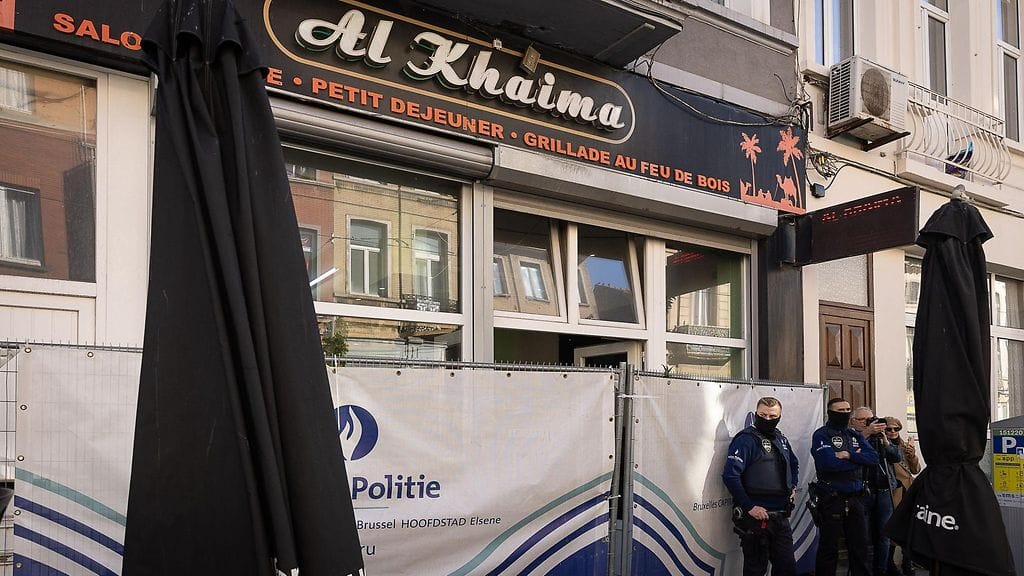 LK 17.10.2023 Belgialaiset poliisit seisovat kahvila Al Khaiman ulkopuolella Brysselissä, jossa iskun epäilty tekijä ammuttiin kuoliaaksi poliisin väliintulon aikana.
