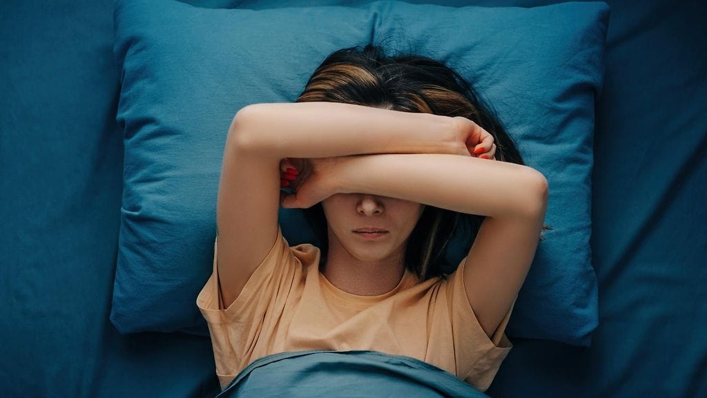 nainen makaa sängyssä