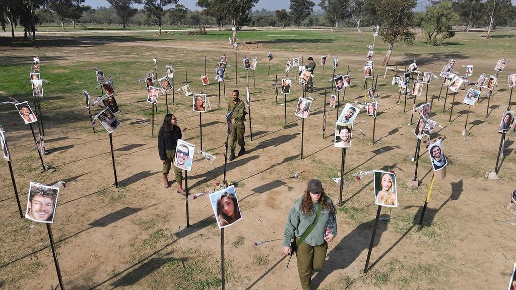 Israelin sotilaat kävelevät Supernova-musiikkifestivaaleilla 7. lokakuuta Hamasin taistelijoiden vangitsemien tai tappamien ihmisten kuvien keskellä.